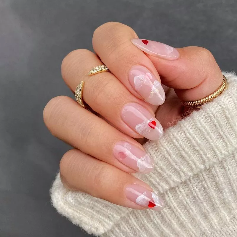 Clear nails with iridescent cloud details and red heart nail decals