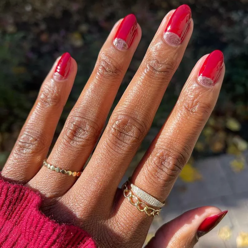 Red nails with rose gold metallic half-moon accents
