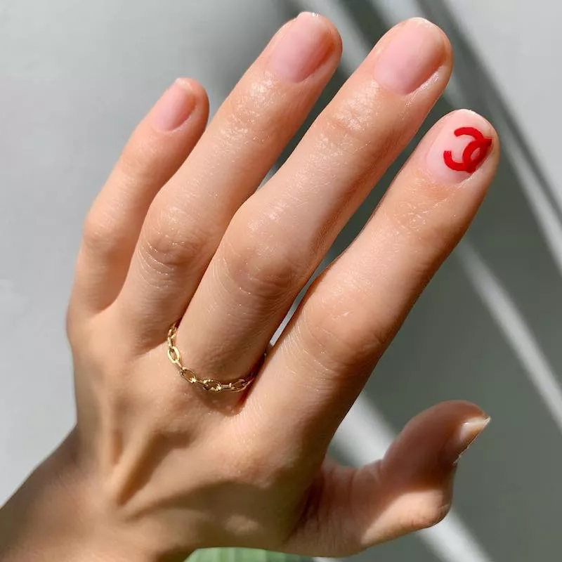 Minimal manicure with red Chanel symbol accent nails