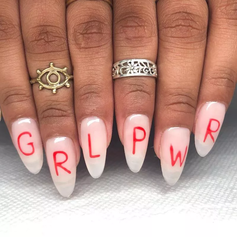 Translucent white acrylic nails with red "GRL PWR" message
