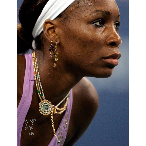Venus Williams of the US wears jewelry in her ears, around her neck, stuck to her skin and on her dress during her match with Daniela Hantuchova of Slovakia in the third round at the 2005 US Open Tennis Tournament