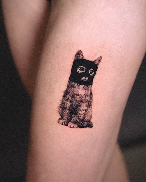 Burglar cat leg tattoo for women by @timur_lysenko