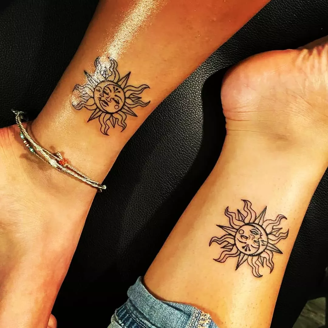 matching black sun tattoos on two ankles