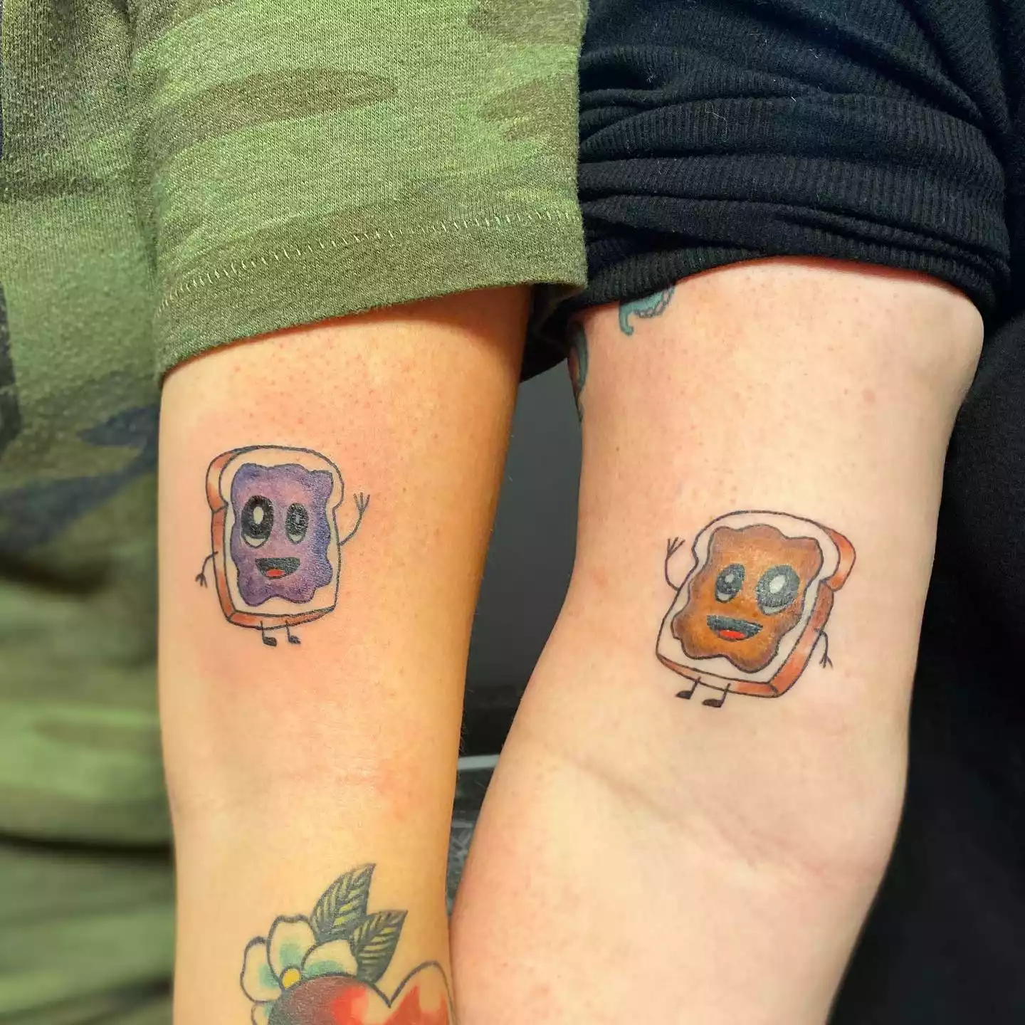 Peanut butter and jelly tattoos on two people's arms