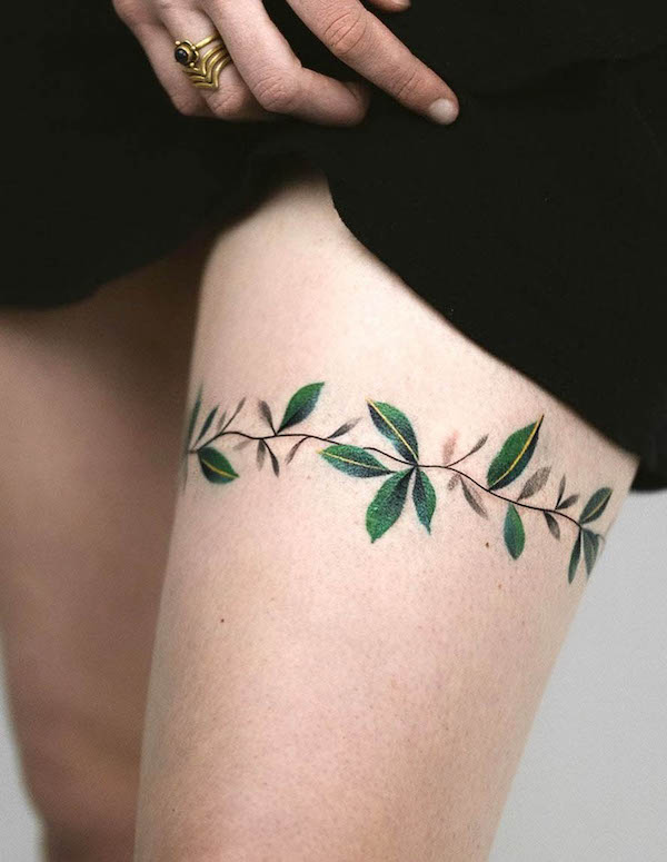 Dainty botanical thigh band tattoo by @rey.jasper