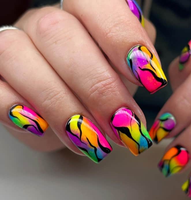 A closeup of a woman's fingernails with color smudges that seamlessly blend together that has an element of edgy refinement, creating an eye-catching masterpiece on your nails