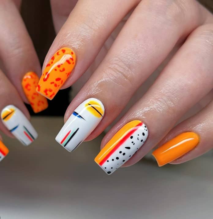 A closeup of a woman's summer coffin fingernails with bright colors like scarlet, orange, yellow, blue, and turquoise that has a delightful array of designs, such as abstract lines with colored smears, vertical streaks of different colors, and playful leopard and Dalmatian animal prints