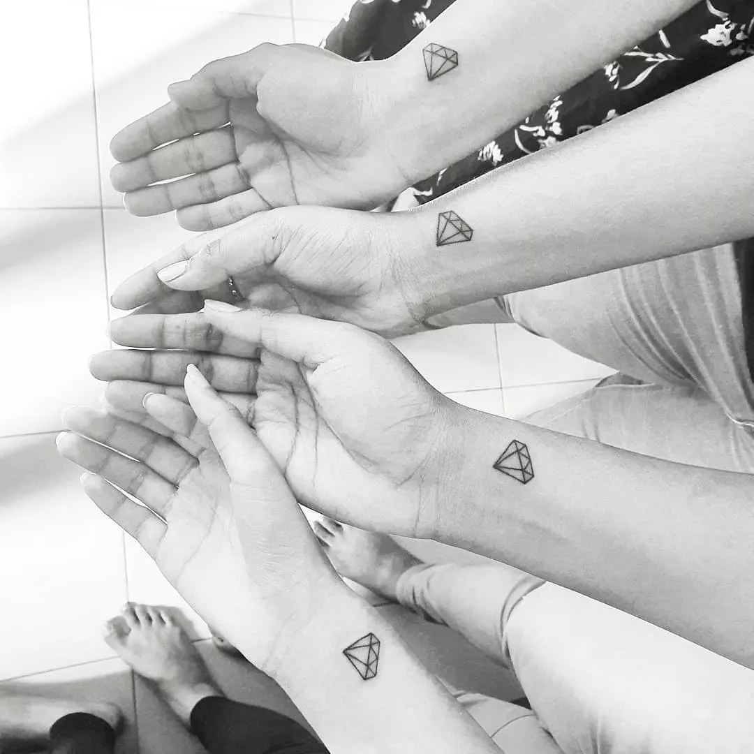 Close up of four wrists with matching diamond tattoos