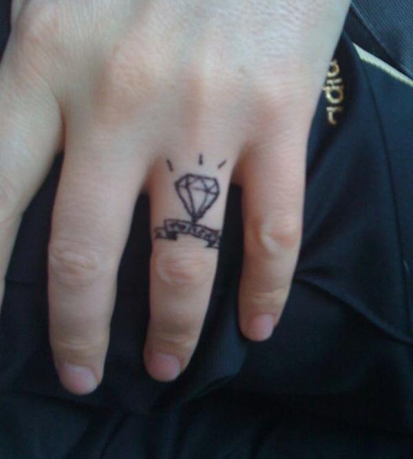 Diamond with banner ink design on ring finger