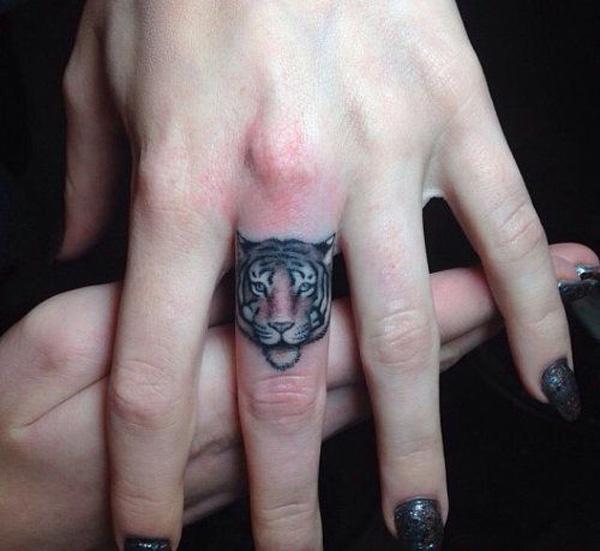 Tiger face tattoo on middle finger