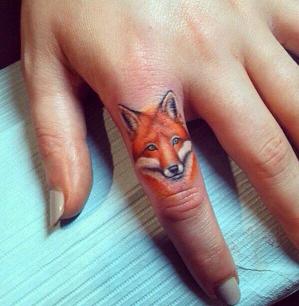 Realistic fox face tattoo on index finger