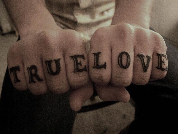 True Lover lettering tattoo on fingers