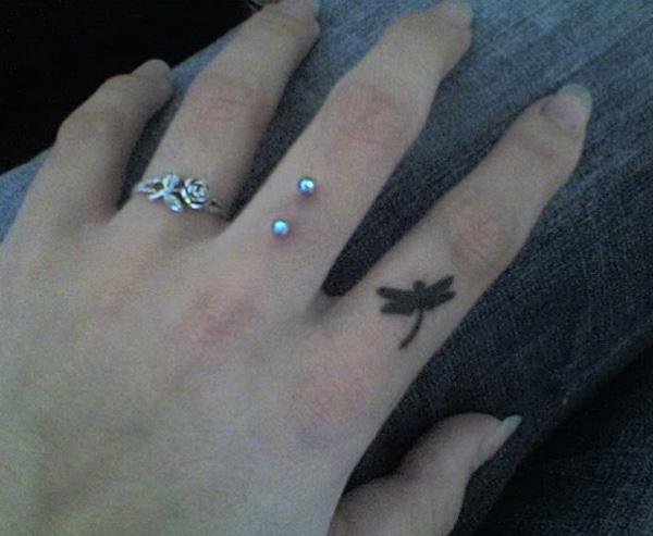 Dragonfly silhouette finger tattoo