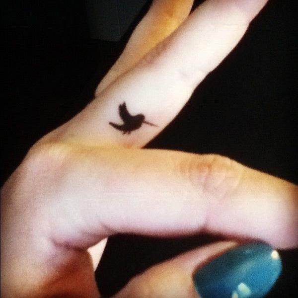 Hummingbird silhouette finger tattoo