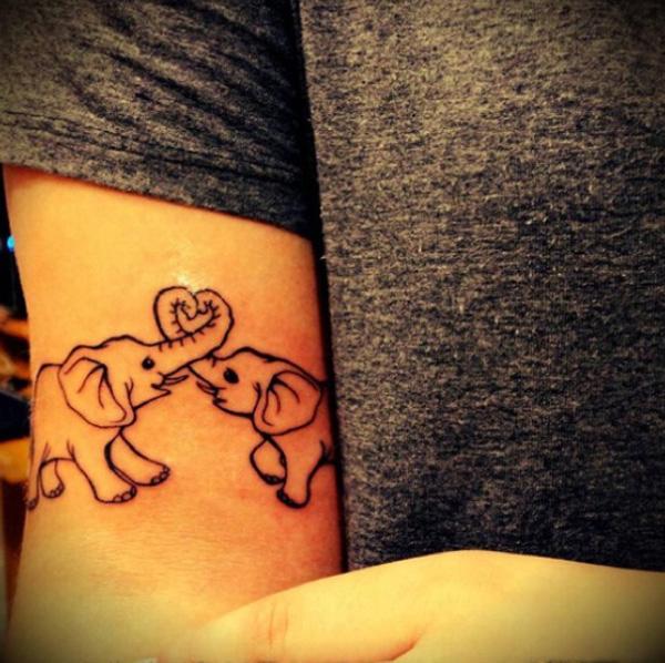 Two playful baby elephants tattoo