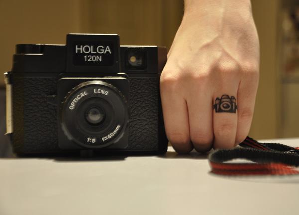 A camera tattoo on ring finger
