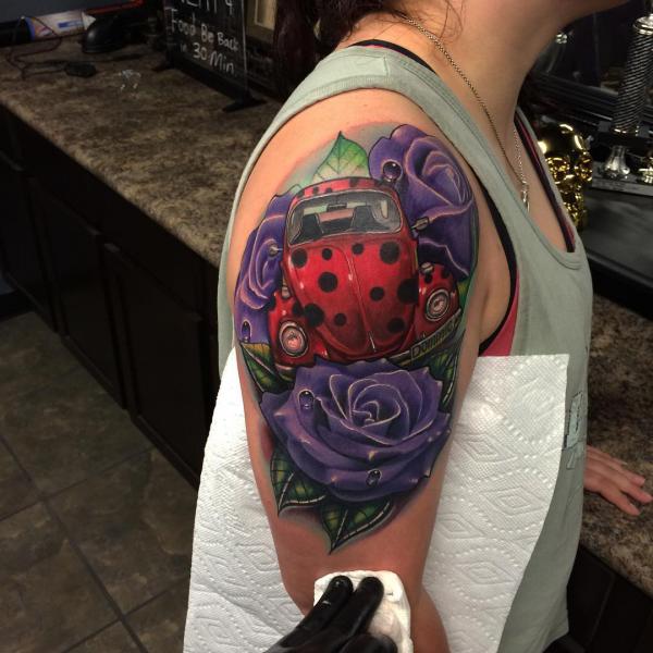 A beetle car surrounded by purple roses