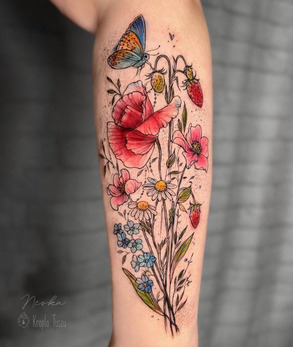 A butterfly near poppy daisy and berry tattoo