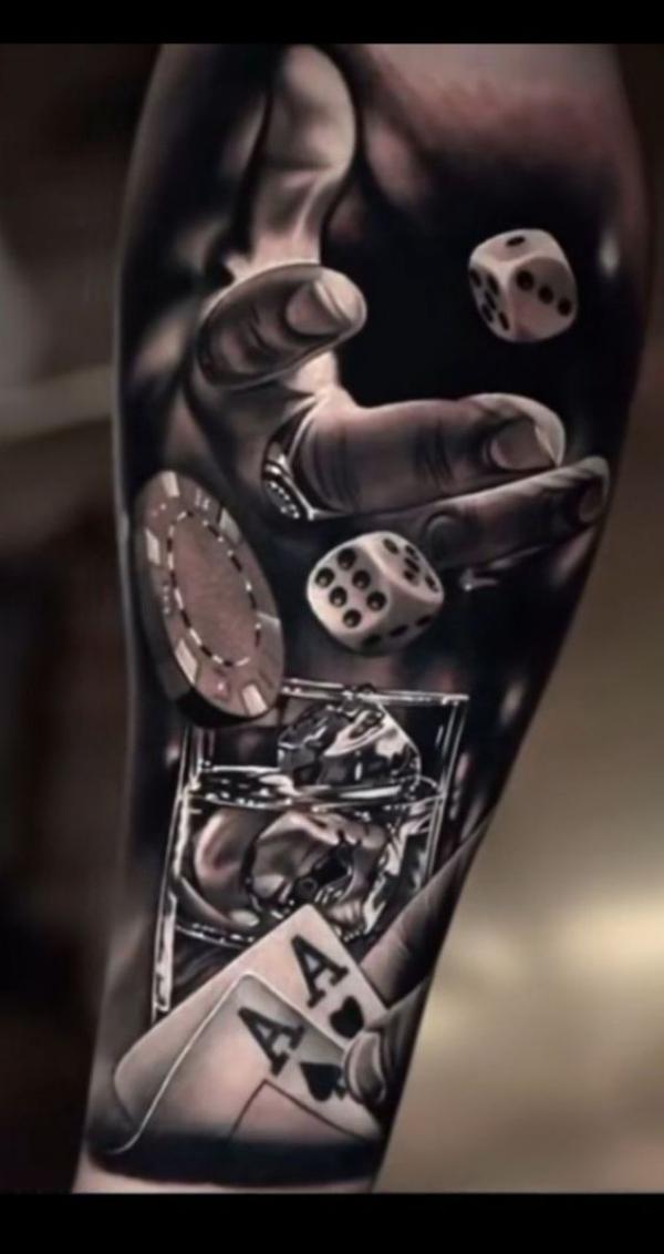 A hand catching the dice over the glass and cards tattoo realistic