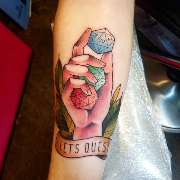 A hand holding three d20 dices Tattoo with words Lets Quest