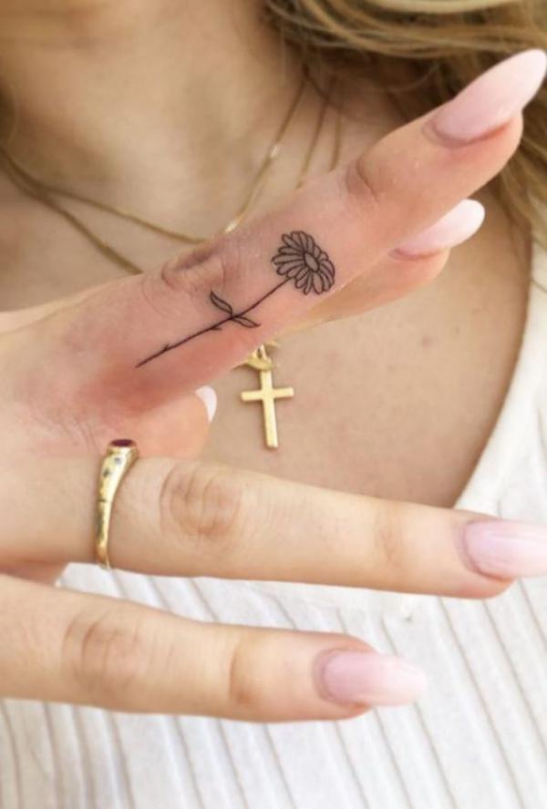 A stem of daisy finger tattoo