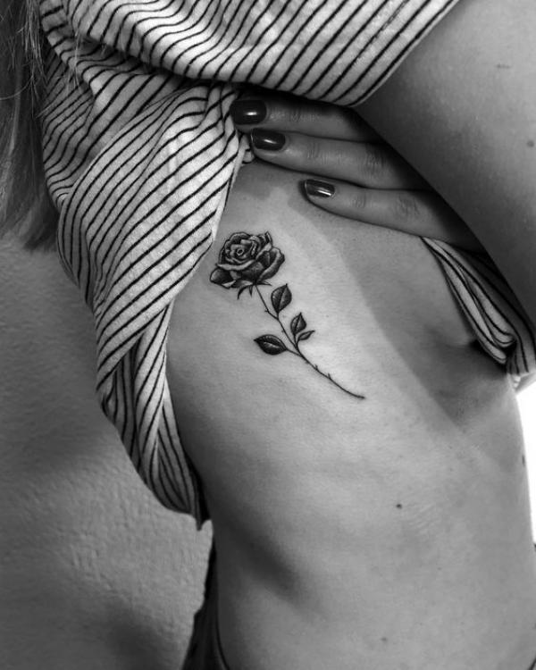 A stem of rose side boob tattoo black and grey