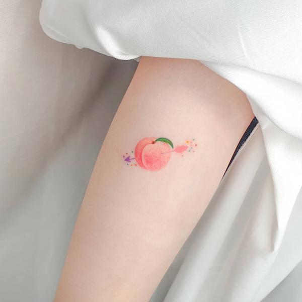 An arrow through a pink peach tattoo
