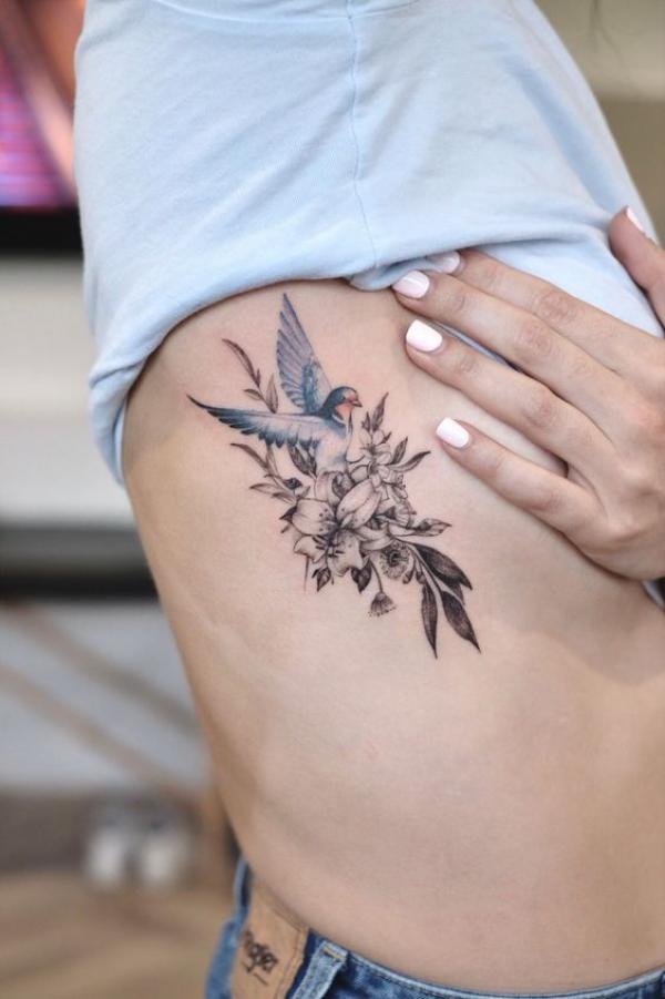 Bird with flowers side boob tattoo