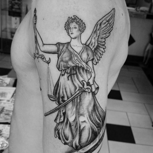 Black and grey Goddess Themis with sword and scales of justice tattoo on upper arm