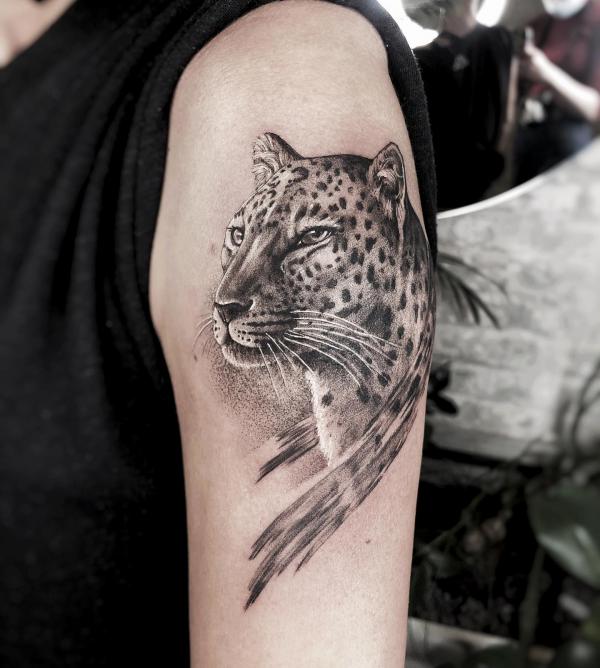 Black and grey Jaguar tattoo on upper arm