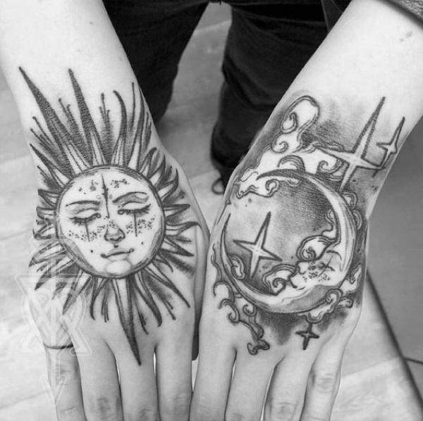 Black and grey Sun and moon face hand tattoo