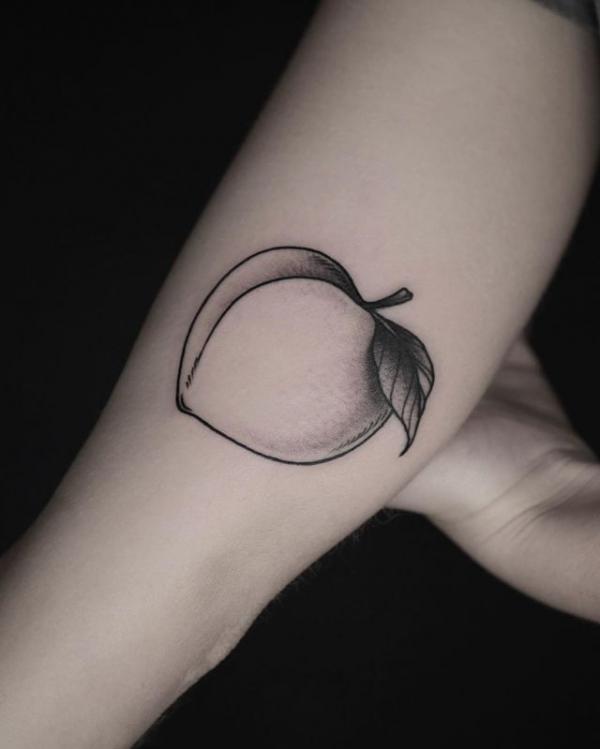 Black and grey single peach tattoo on upper arm
