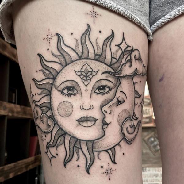 Black and grey sun and moon face tattoo on thigh