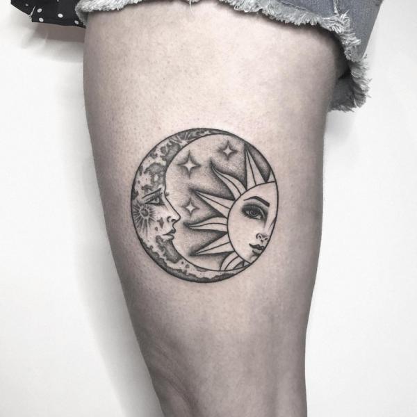 Black and grey sun and moon face thigh tattoo