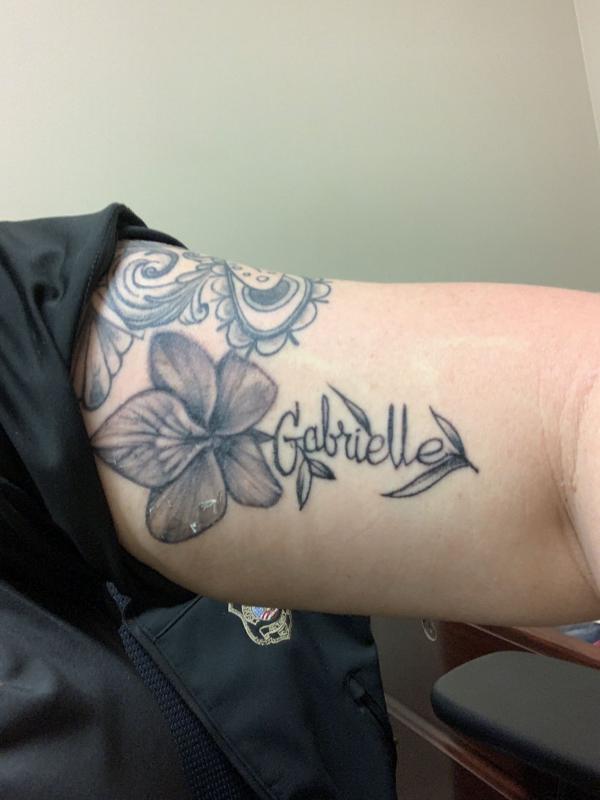 Black and grey violet flower with name on bicep