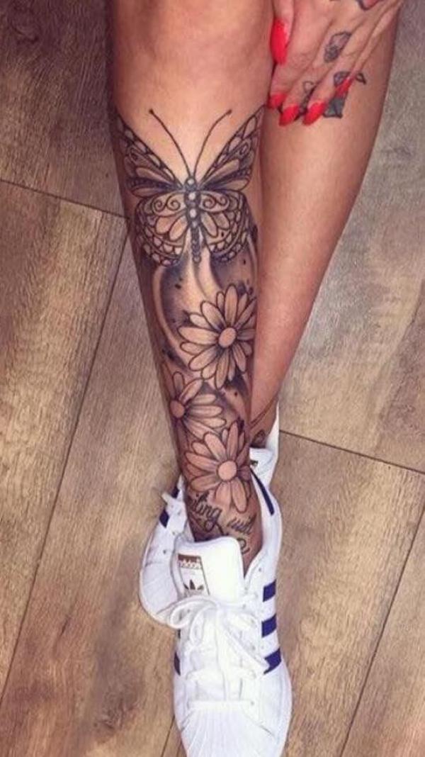 Black and white butterfly and daisy lower leg tattoo