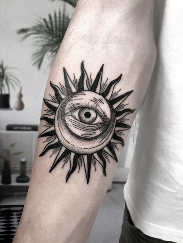 Black and white moon in sun with eye tattoo