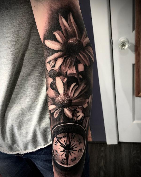 Black daisy and compass tattoo