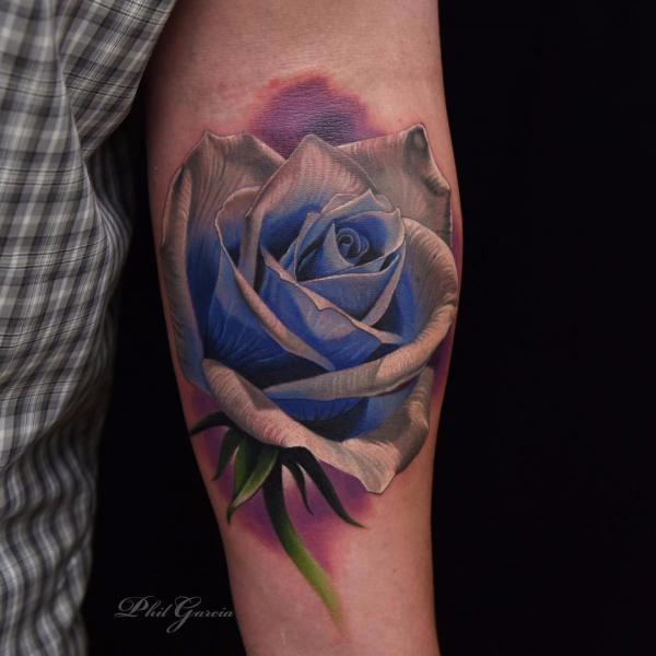 Blue and grey rose ink design on inner forearm