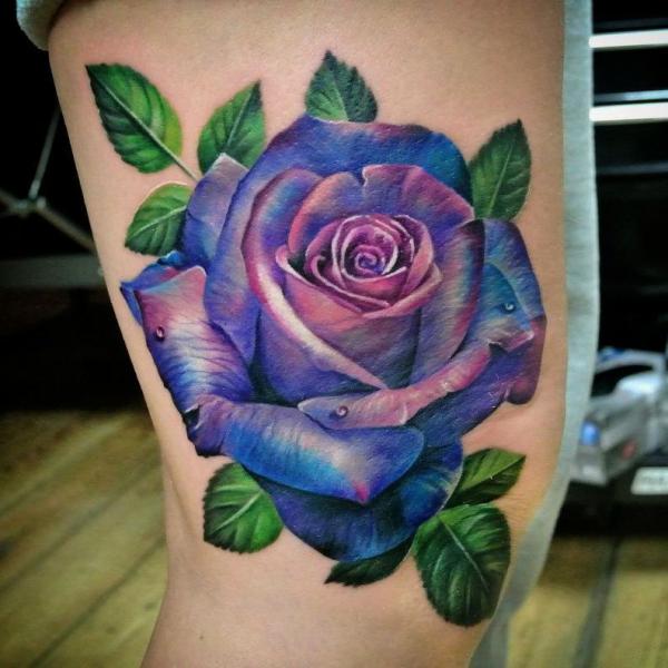 Blue and purple rose tattoo on side of knee