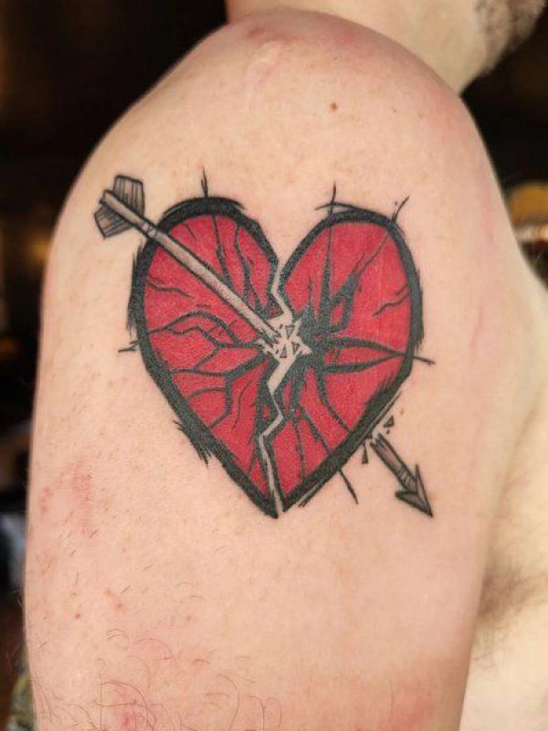 Broken heart with an arrow through it tattoo