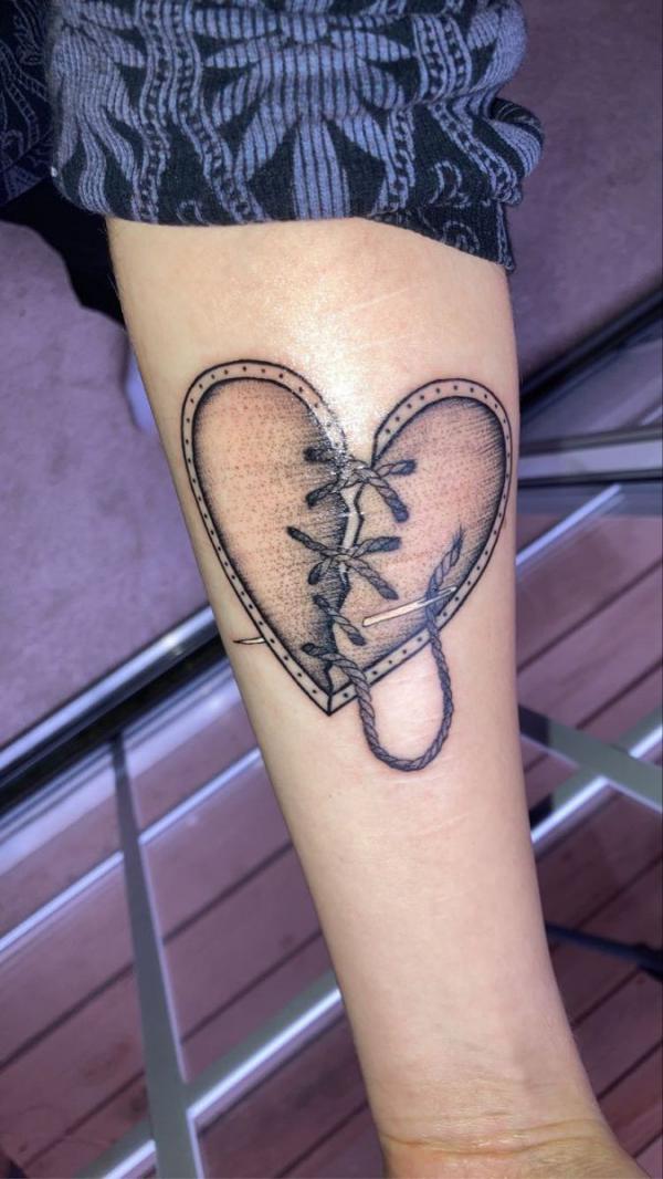 Broken heart with stitches tattoo