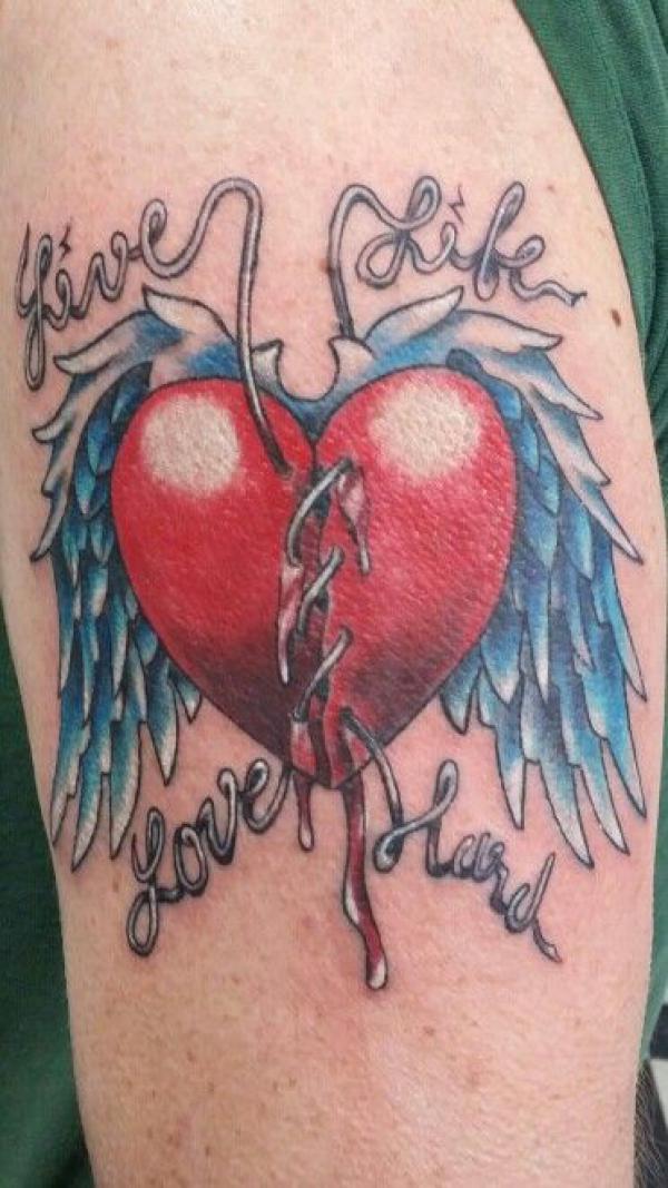 Broken heart with wings and stitched by iron wire tattoo