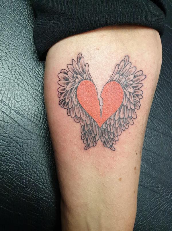 Broken heart with wings arm tattoo