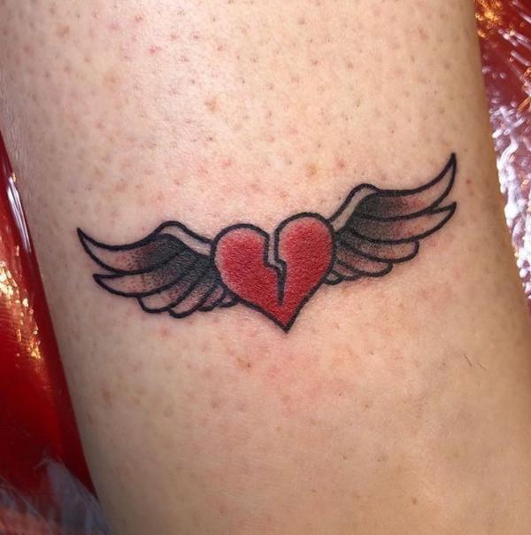 Broken heart with wings tattoo on arm