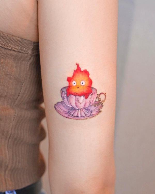 Calcifer in cup back of arm tattoo