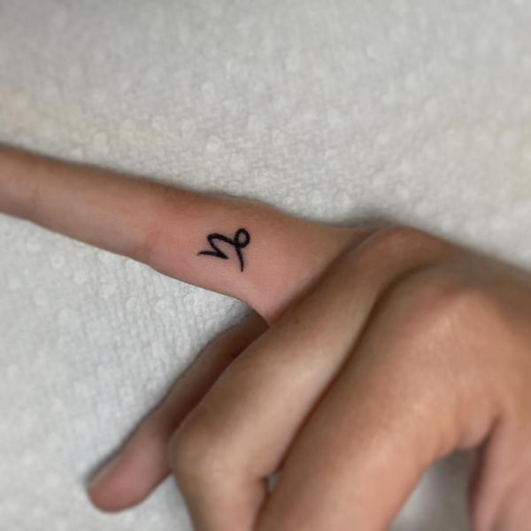 Capricorn glyph finger tattoo