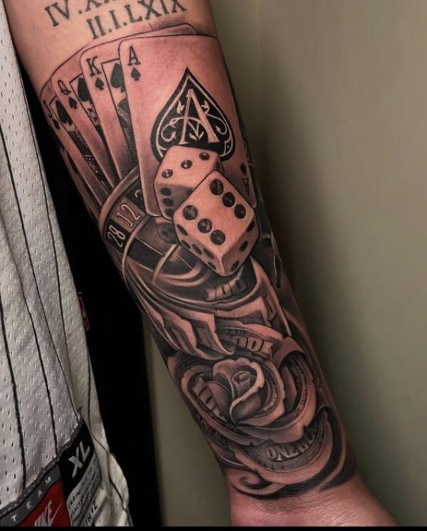 Cards dices and money rose tattoo forearm