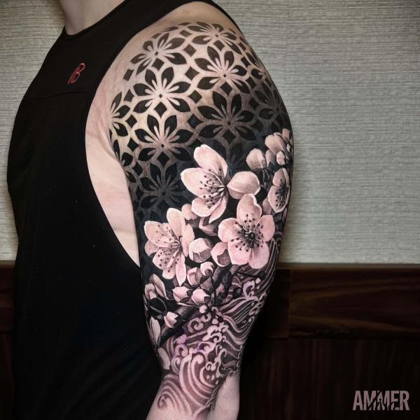 Cherry blossom on geometric and wave patterns upper arm tattoo