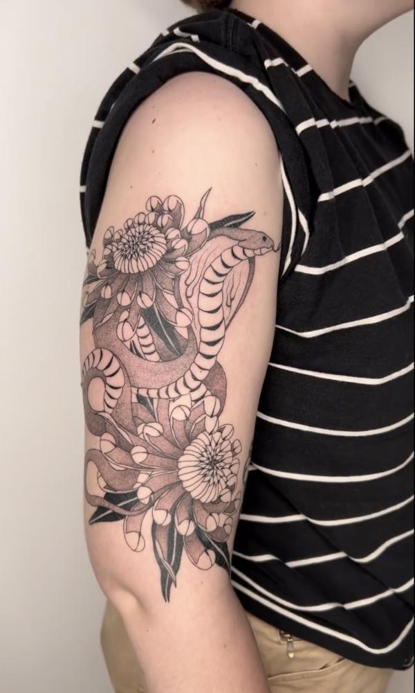 Cobra and flower tattoo on upper arm